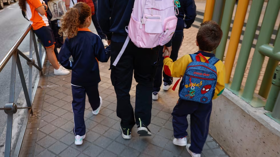 Un padre acerca a sus hijos al colegio, en abril de 2025, en Madrid | Mariscal (EFE)