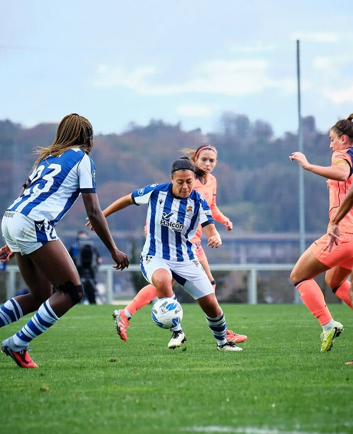 Paula Fernández controla el esférico frente la atenta mirada de Alexia Putellas y Aitana Bonmatí. Fuente: @realsociedadfem.