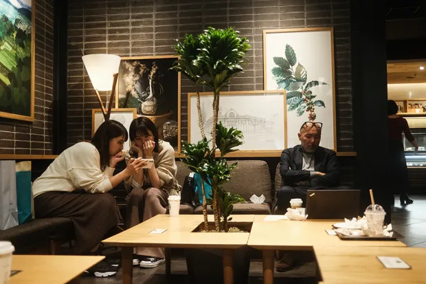 3 personas sentadas en una cafetería